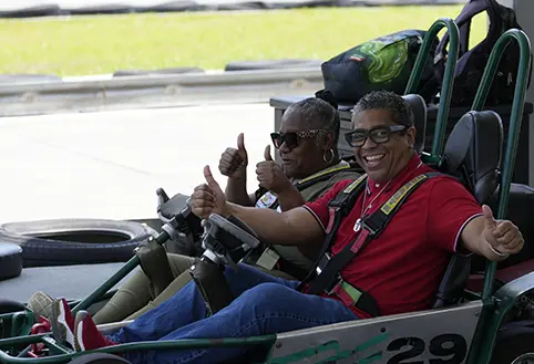 Nuvotronics employees on a go-cart smiling at camera